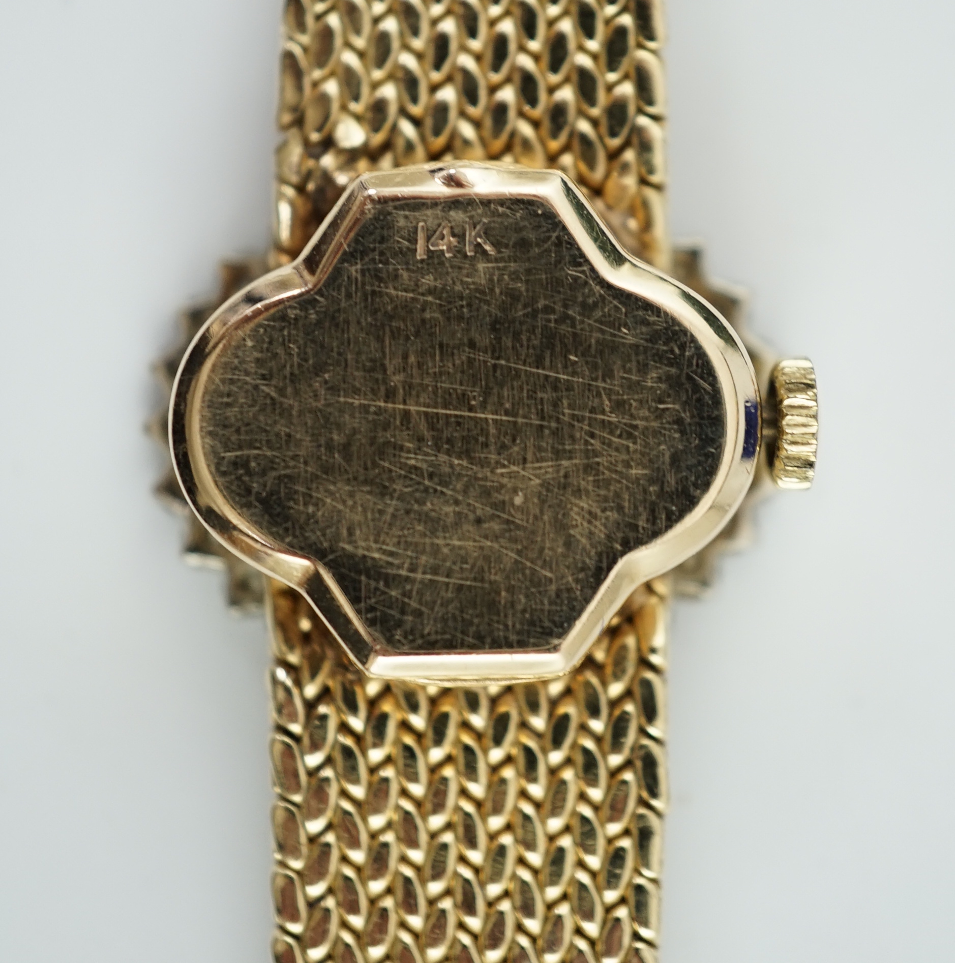 A lady's modern Swiss 14k gold and diamond set manual wind oval wrist watch, on integral 14k gold bracelet